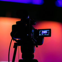 Silhouette of a video camera filming a live service broadcast